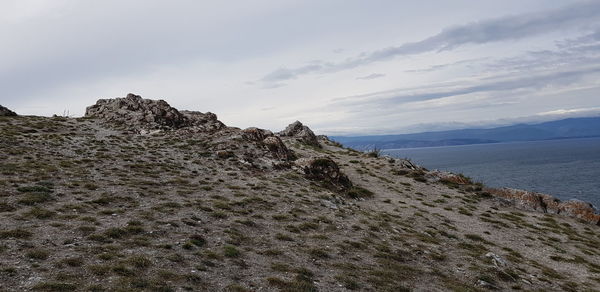 Scenic view of rocky shore and sea against sky