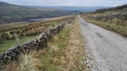 Road amidst field against sky