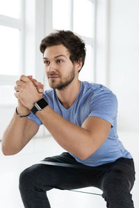 Young man using mobile phone while sitting at home