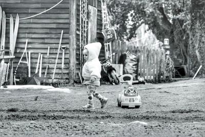 Rear view of boy with toy against trees