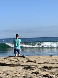 Rear view of man standing on beach