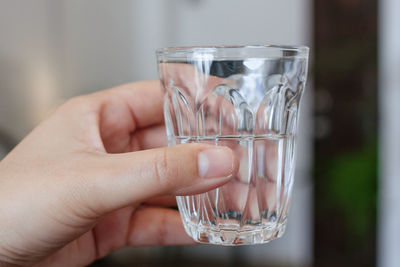 Midsection of person holding glass of water