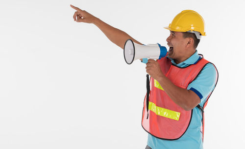 Man with arms raised standing against white background