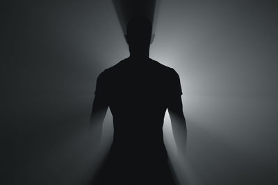 Rear view of silhouette woman standing against white background