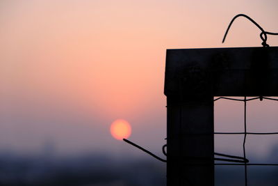 Close-up of silhouette metal against sky during sunset