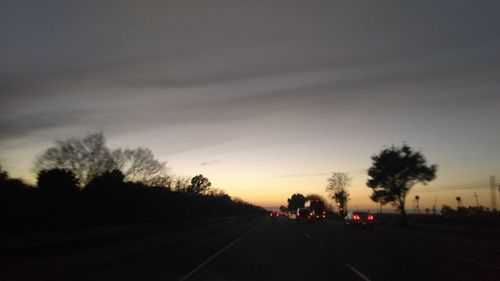 Road in city against sky during sunset