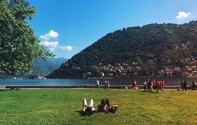 People on shore against sky