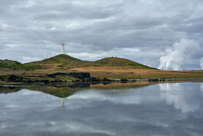 Scenic landscape of lighthouse on hill in cloudy day