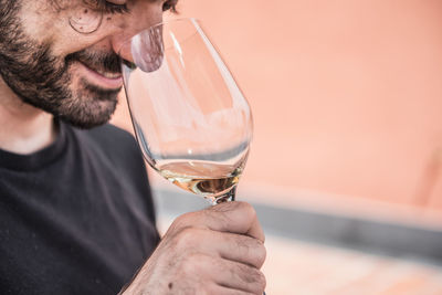 Close-up of smiling man smelling wine