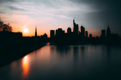 Silhouette buildings against sky during sunset