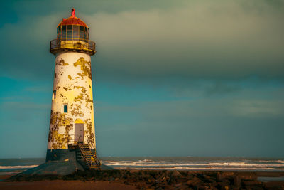 Lighthouse against cloudy sky