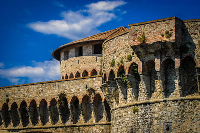 Low angle view of old building against cloudy sky