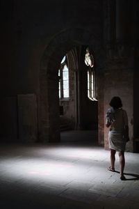 Rear view of woman walking in corridor