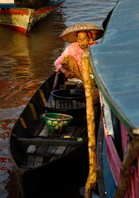 High angle view of woman sitting on boat in canal