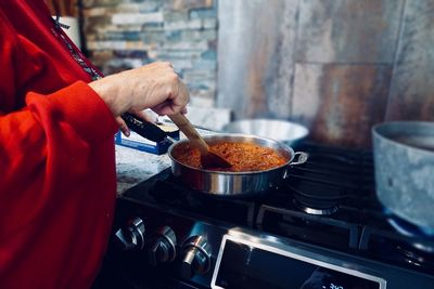 Midsection of woman preparing food in kitchen at home