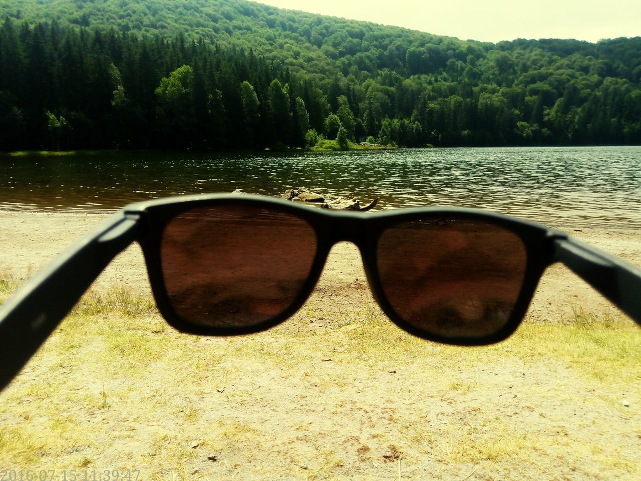 water, lake, tree, reflection, tranquility, tranquil scene, scenics, nature, mountain, sky, outdoors, day, beauty in nature, close-up, lakeshore, no people, idyllic, landscape, non-urban scene, part of, calm, remote, focus on foreground