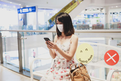 Woman using mobile phone in office