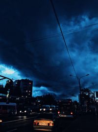 Cars on road in city against sky at night