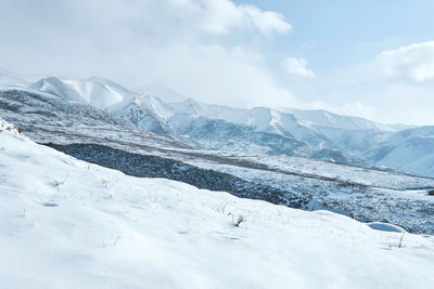 Scenic view of snowcapped mountain against cloudy sky