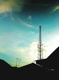 Low angle view of silhouette communications tower against sky