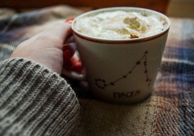 Close-up of hand holding coffee cup