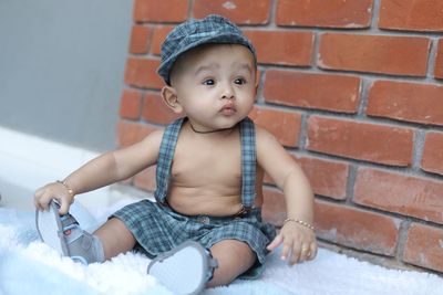 Cute baby girl sitting on wall