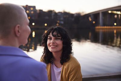 Young woman looking away, river in background