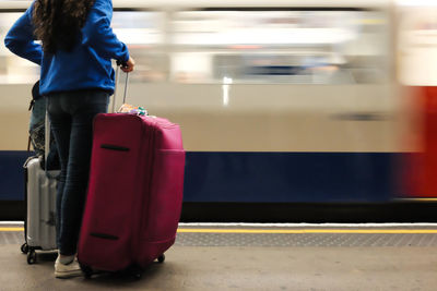 Blurred motion of woman standing at railroad station