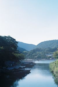 Scenic view of river and mountains against clear sky