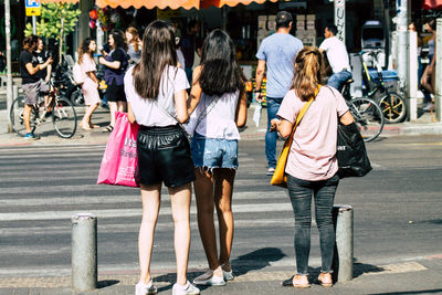 Rear view of people walking on street