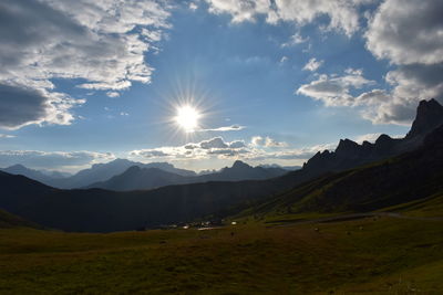 Scenic view of field and mountains against sky