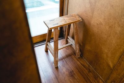 High angle view of wooden stool by window