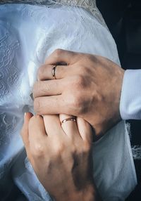 Cropped image of newlywed couple holding hands