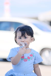 Portrait of cute girl eating ice cream outdoors