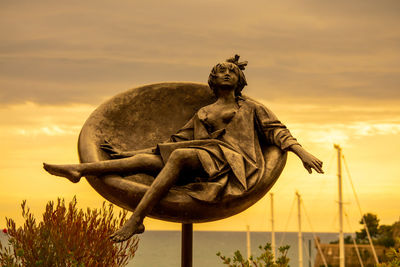 Low angle view of statue against sky during sunset