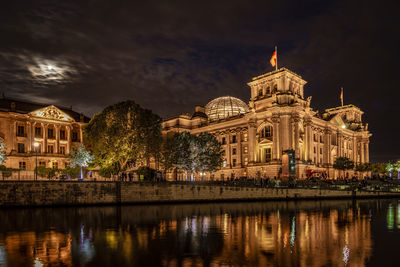 Illuminated building in water at night