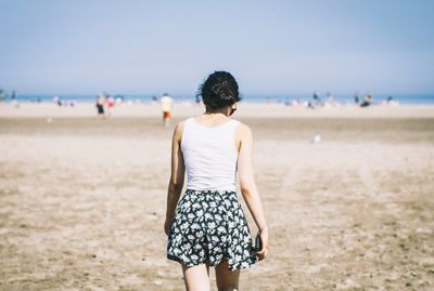 Rear view of woman standing on beach