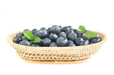 Close-up of fruits in basket against white background