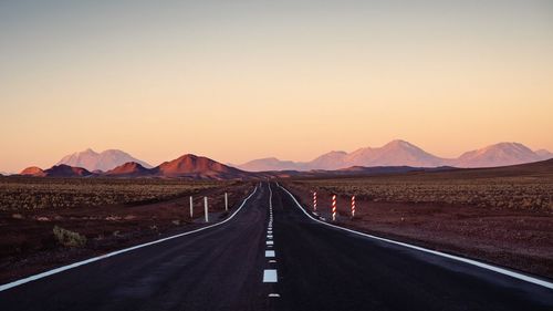 Road leading towards mountains against sky