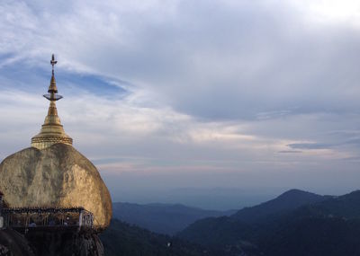 Scenic view of mountains against cloudy sky at sunset