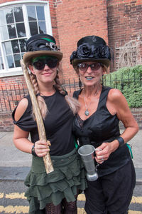 Portrait of woman holding sunglasses outdoors