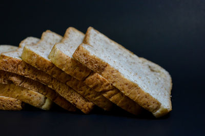 Close-up of bread on table against black background