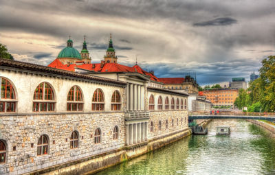 Bridge over river against buildings in city