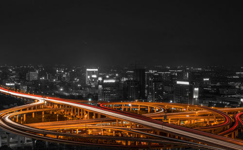 High angle view of light trails on highway in city at night