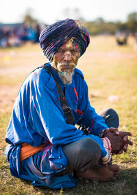 Portrait of man sitting on field