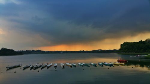 Boats in sea against cloudy sky