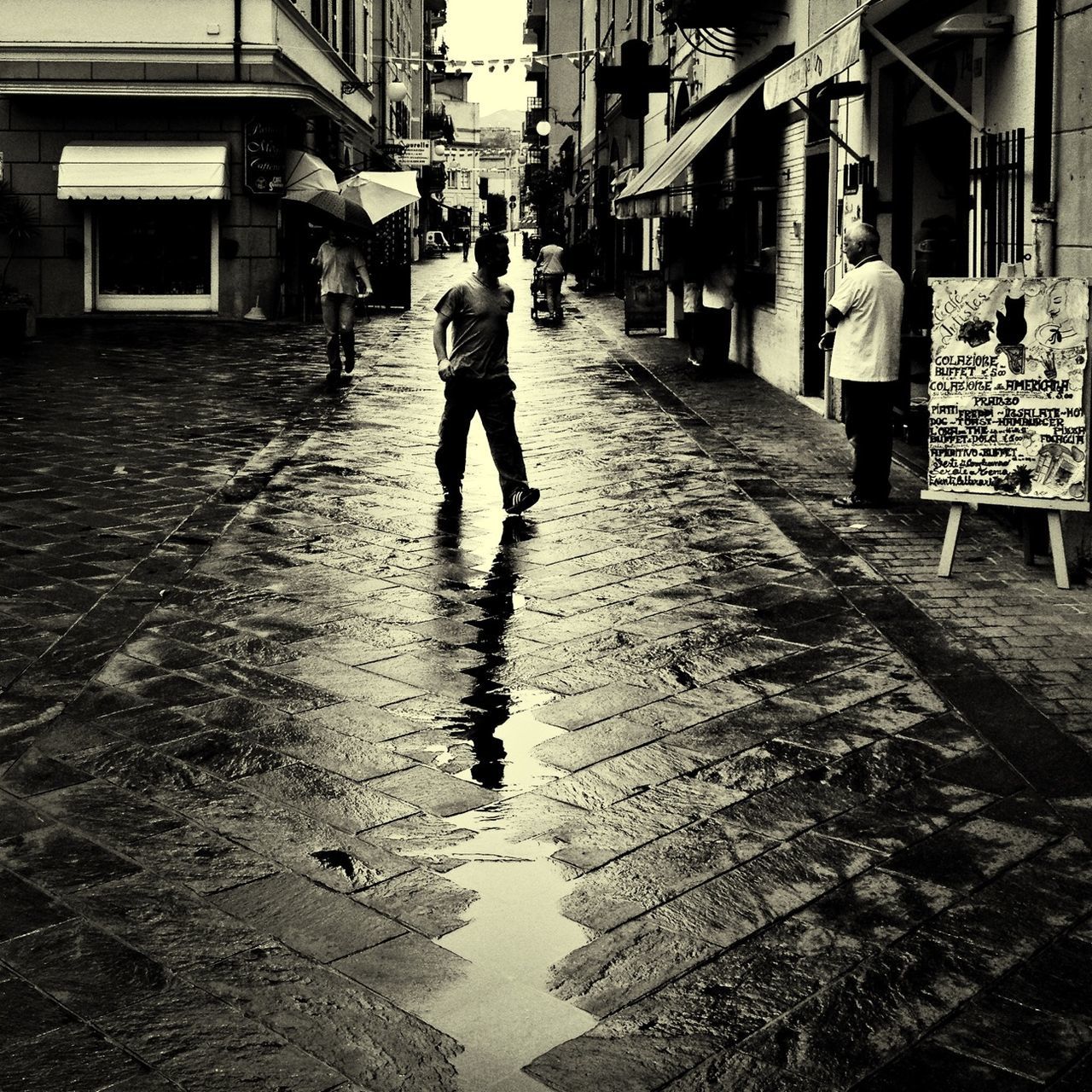 building exterior, full length, walking, architecture, built structure, lifestyles, street, wet, rear view, city, water, men, leisure activity, city life, person, the way forward, rain, casual clothing