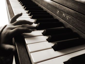 Cropped hands of child playing piano