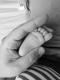 Midsection of woman holding baby hand