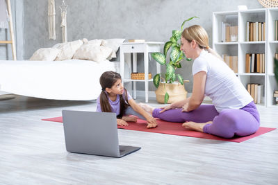 Woman with daughter doing home workout